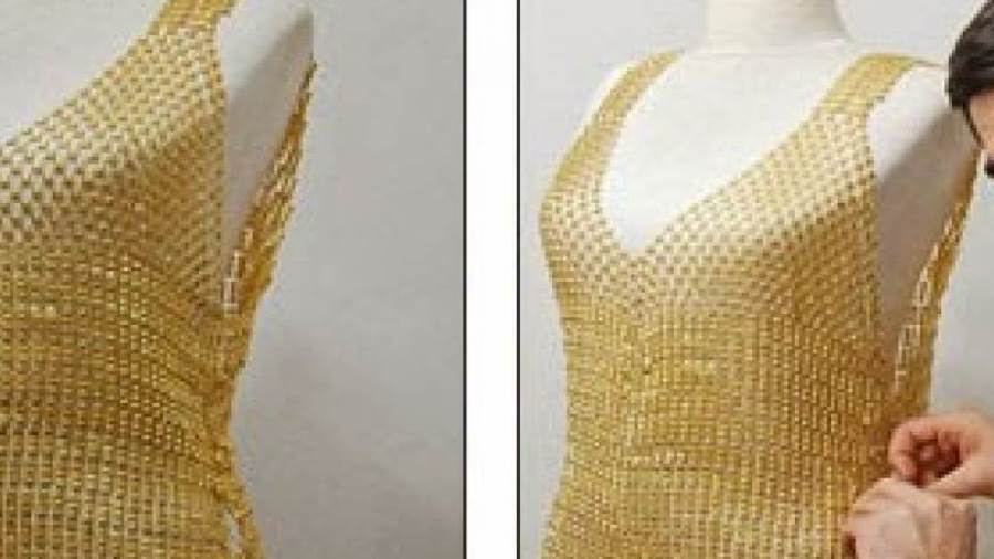 الفستان يعرض ضمن أسبوع دبي الدولي للمجوهرات وهو مصنوع من الذهب الصافي من عيار 24 قيراطا وثوب زفاف من الذهب في أسبوع دبي الدولي للمجوهرات وفي الصورة القماش الذهبي المستخدم في صناعة الفساتين