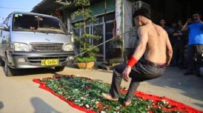 الرجل الخارق الذى يجر الشاحنه بأسنانه وهو يسير على قطع زجاج