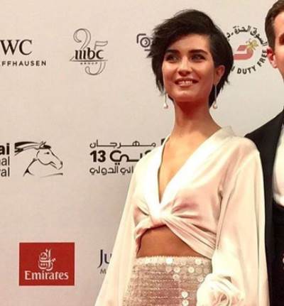 بالصور .. توبا بويوكوستين بإطلالة بيضاء مكشوفة البطن بمهرجان دبي