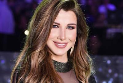  شاهد .. نانسي عجرم تثير الجدل بـ مايوه اسود مفتوح الصدر