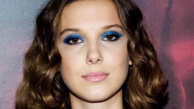 ميلى بوبى براون تبرز أنوثتها بفستان أحمر مكشوف من الظهر