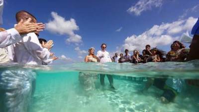 عروسان يحتفلان بزواجهما بالقفز فى البحر بملابس الزفاف